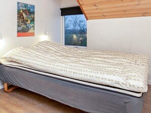Ein Schlafzimmer mit Bett, Fenster und einem Bild an der Wand.