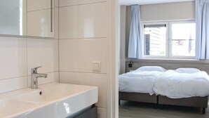 Une salle de bain moderne avec un grand lavabo blanc et un miroir au-dessus.