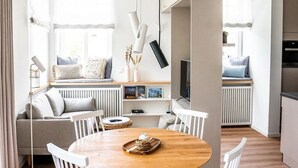 A modern, open-plan living space with a dining area, seating, and a kitchen. - Luxury & Design With sea View (Kuehlungsborn)