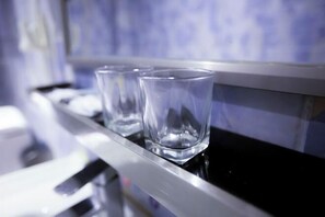 Two clear glasses on a metallic surface with a blurred background. - SHENZHEN FEIYOUMEI HOTEL (Shenzhen)