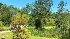 A park with a white metal fence, lush greenery, and a clear blue sky. - 4 Person Holiday Home in Tonder-by Traum (Tonder)