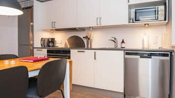 Eine moderne Küche mit weißen Schränken, Edelstahlgeräten und einem Holzespeisetisch.