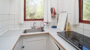 A small kitchen with a window, a sink, and a stove. - 5 Person Holiday Home in Rorvig (Rørvig)