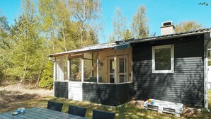A small cabin with a covered porch, a dining table, and chairs. - 5 Person Holiday Home in Rorvig (Rørvig)