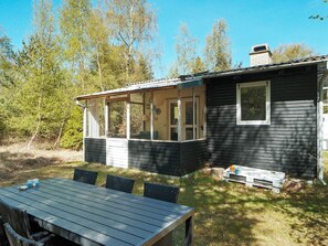 A small cabin with a covered porch, a dining table, and chairs. - 5 Person Holiday Home in Rorvig (Rørvig)