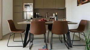 A modern kitchen with a central island, four chairs, and a dining table. - Villa Dora - Apt 4 "bruin" (Pula)
