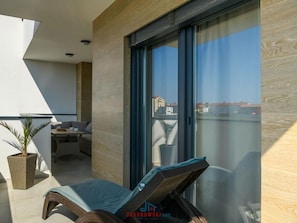 A balcony with a lounge chair, a small table, and a potted plant. - Villa Dora - Apt 4 "bruin" (Pula)
