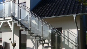 Ein modernes Gebäude mit einer gläsernen Wendeltreppe, die zu einer zweiten Etage führt.