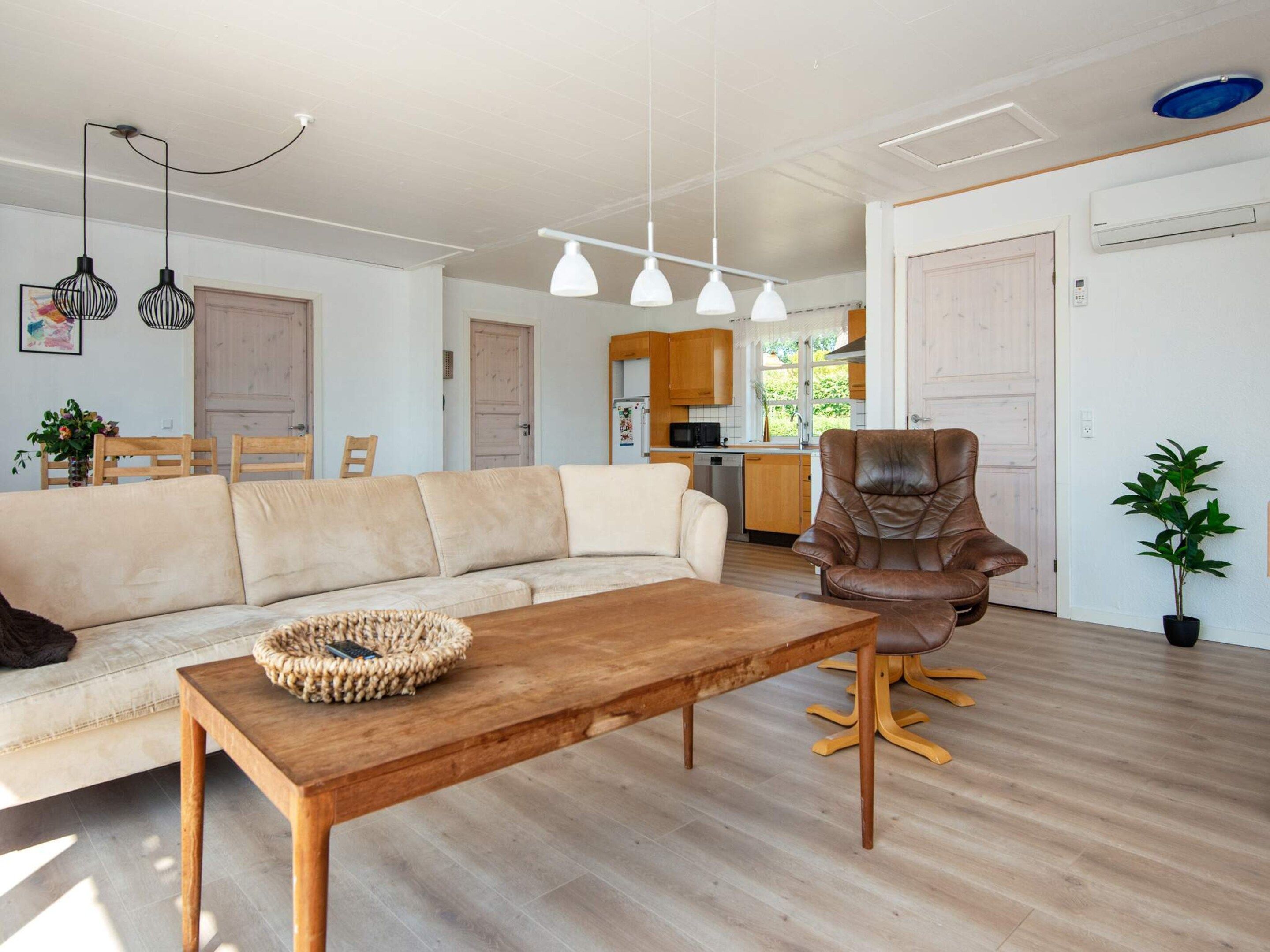Ein modernes Wohnzimmer mit einer Couch, einem Couchtisch aus Holz und einem Ledersessel.