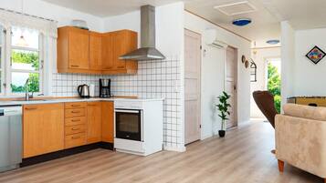 Cozinha moderna com armários de madeira, forno embutido e painel de azulejos.