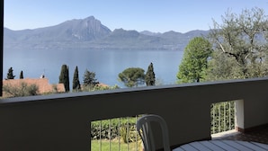 Uma varanda com vista para um lago e montanhas.