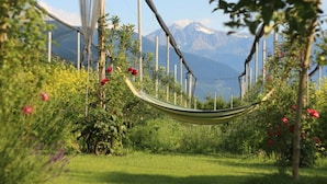 Una hamaca en un jardín exuberante con vistas a la montaña.
