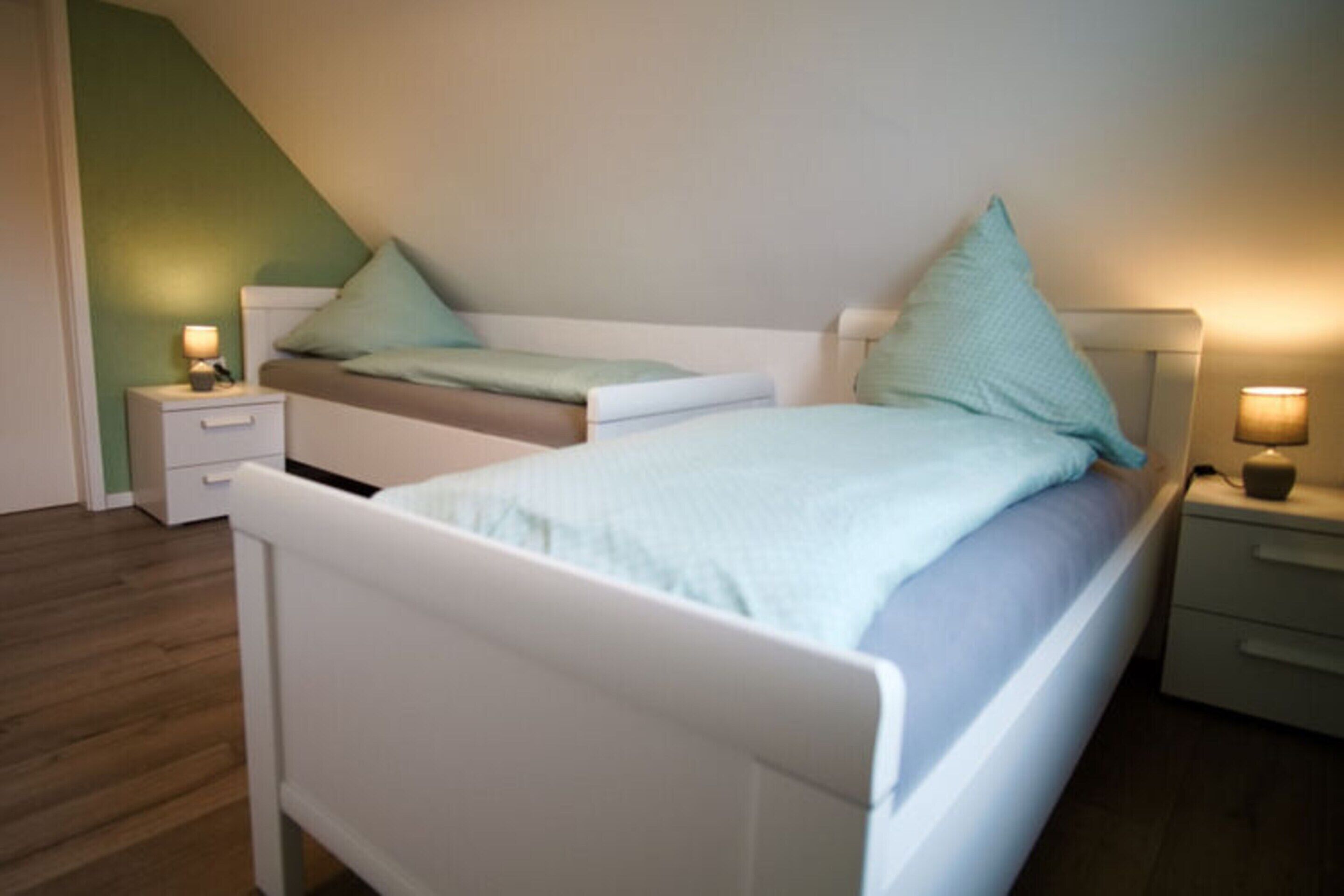 Un dormitorio con una cama, dos mesitas de noche y un tocador.