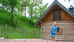 A log cabin with a stone platform and a pond. - Infanglalm "traunsee" (Altmuenster)
