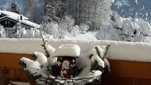 A snowy outdoor area with a wooden bench and a decorative Christmas tree. - Kehlstein - Reich Family (Schoenau am Koenigssee)