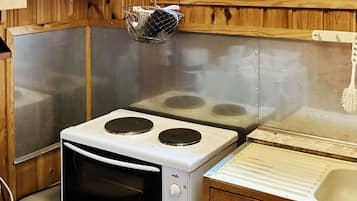 A compact kitchen with a stove, oven, and sink.