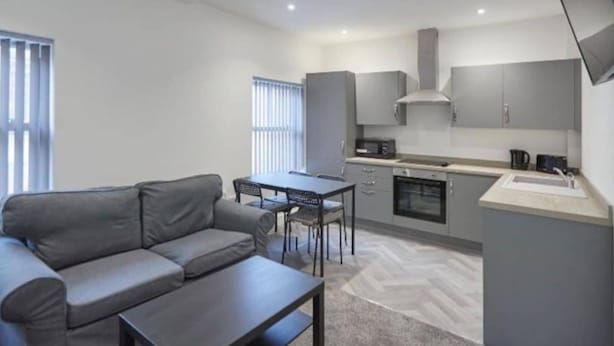 A compact living space with a sofa, dining table, and kitchenette. - Apartment 4 in Loftus (Saltburn-by-the-Sea)
