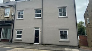 A two-story building with a flat facade, multiple windows, and a central door. - Apartment 4 in Loftus (Saltburn-by-the-Sea)