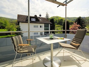 A balcony with two chairs, a table, and a glass barrier. - Savoir Vivre Modern Retreat (Endingen am Kaiserstuhl)