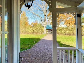 A covered walkway leading to a building with a green roof, surrounded by trees and a grassy area. - 5 Star Holiday Home in Bello (Hjältevad)