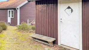 A wooden building with a door and a small bench outside.