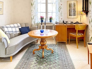 A living room with a sofa, a round wooden table, a wooden desk, and a chair. - 4 Person Holiday Home in Vimmerby (Vimmerby)