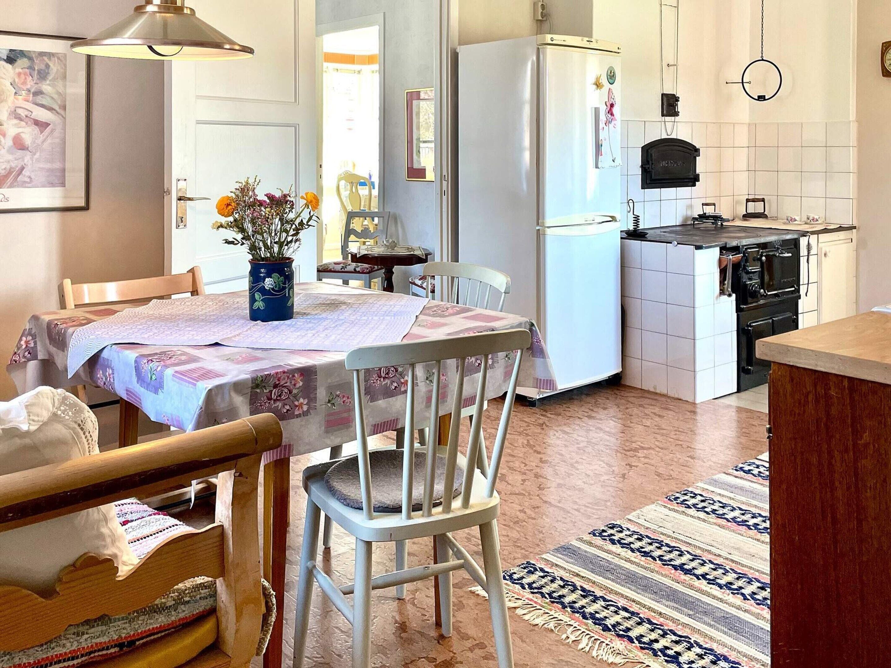 A kitchen with a dining area, a refrigerator, a stove, and a sink.