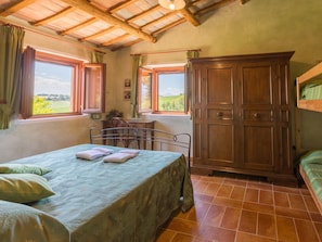 Un dormitorio con cama, escritorio y armario.