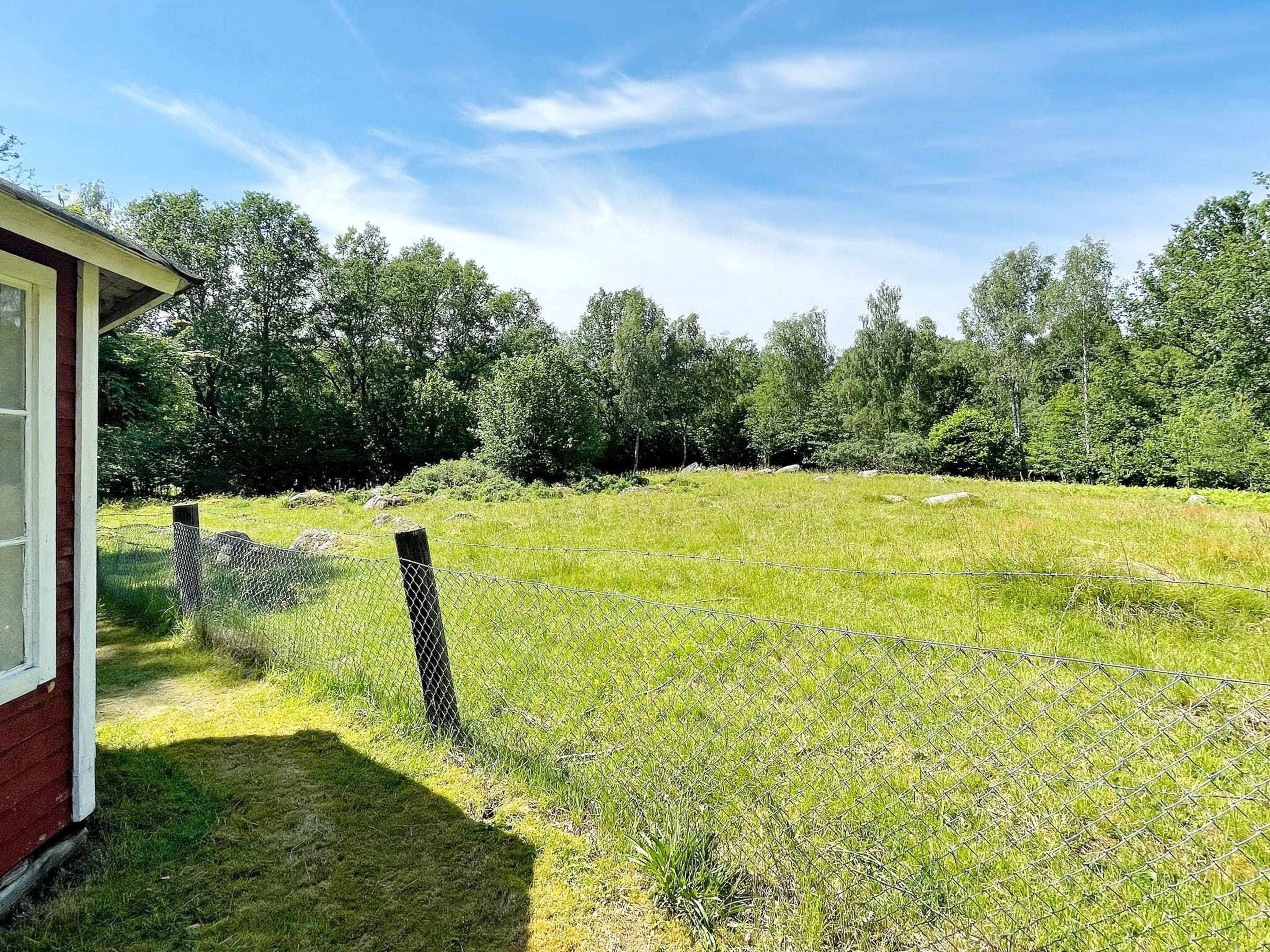 A fenced yard with a house on the left.