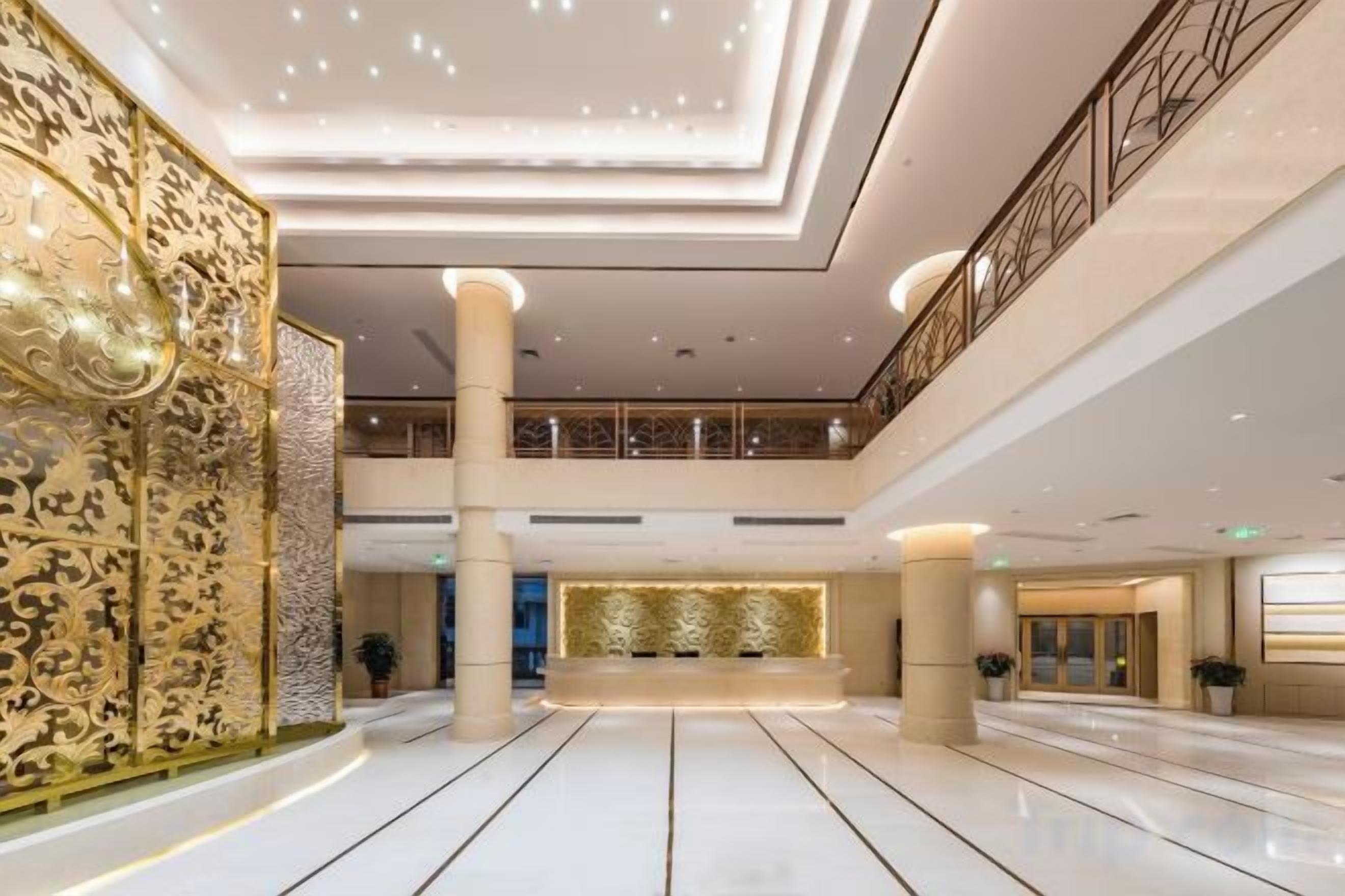 Un hall d’entrée spacieux, doté d’un haut plafond, de grandes colonnes et d’un espace de réception central.