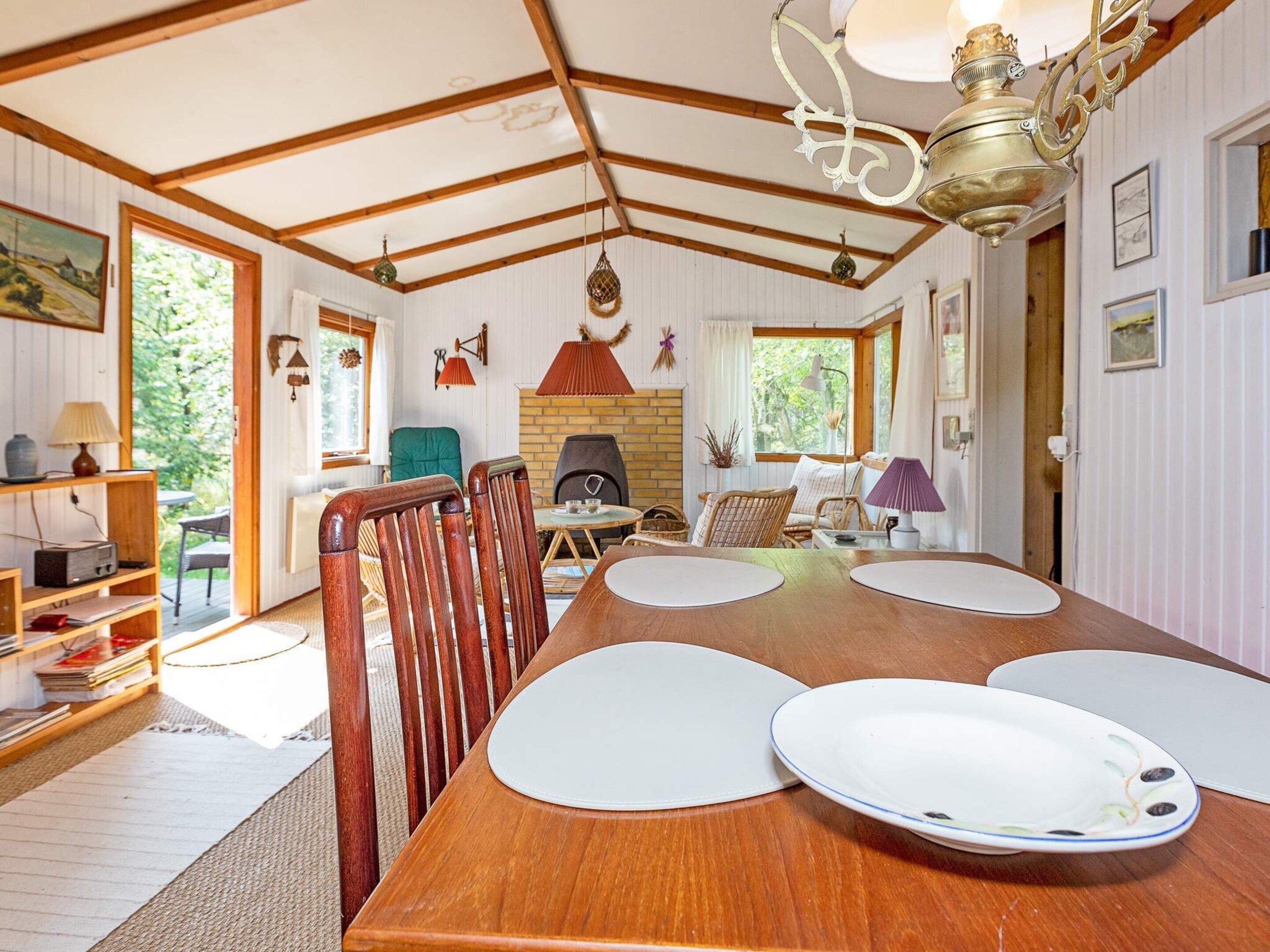A dining area with a wooden table, chairs, and a chandelier.