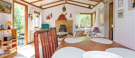 A dining area with a wooden table, chairs, and a chandelier.
