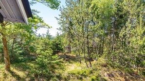 A forested area with a building partially visible on the left. - 4 Person Holiday Home in Blokhus (Blokhus)