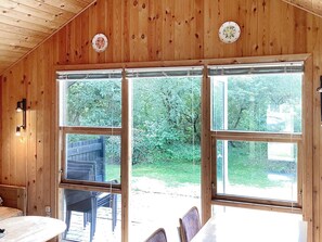 A wooden interior with large windows, a dining table, and chairs. - 4 Person Holiday Home in Hovborg (Hovborg)
