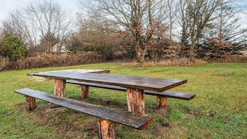 Ein Picknicktisch in einer grünen Umgebung mit Bäumen im Hintergrund.
