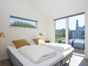 Un dormitorio con dos camas, una ventana y vistas a un edificio.