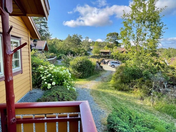 A wooden building with a gravel pathway leading to a car parked in a driveway. - 9 Person Holiday Home in Mosterhamn (Bomlo)