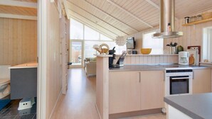 Une cuisine moderne avec des meubles en bois, une hotte en acier inoxydable et un four encastré.