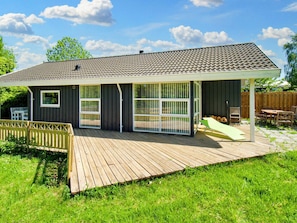 A house with a covered patio area, a fenced yard, and a wooden deck. - 6 Person Holiday Home in Skibby (Skibby)