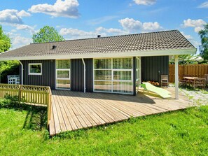 A house with a covered patio, a fenced deck, and a wooden fence. - 6 Person Holiday Home in Skibby (Skibby)