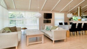 Un salon comprenant un canapé, une table basse et un coin repas avec une table et des chaises.