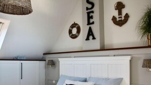 A bedroom with a bed, a wall-mounted lamp, and a ceiling light fixture. - Nice Apartment With Wifi (Kuehlungsborn)