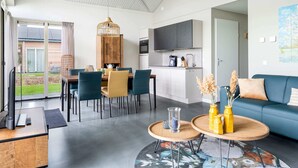 Um espaço de estar moderno com área de refeições, cozinha e sala de estar.