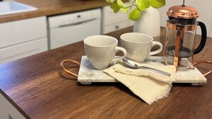 A kitchen counter with two white cups, a glass coffee pot, and a spoon on a marble coaster. - Home in Downtown Redmond Oregon and in the heart of Central Oregon.  (Redmond)