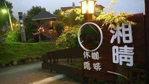 A sign with Japanese characters and a circular emblem, likely indicating a hotel or lodging establishment. - Xiangqing Garden Leisure Cabin (Nantou)