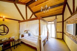 A bedroom with a four-poster bed, a wooden desk, a mirror, and a chandelier. - Xiangqing Garden Leisure Cabin (Nantou)