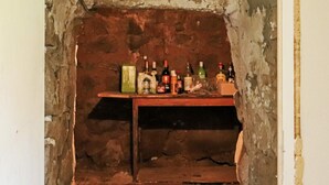A rustic room with a wooden table displaying various bottles. - 6 Person Holiday Home in Hishult (Hishult)