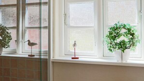 A room with a window, a brick wall, and a potted plant. - 6 Person Holiday Home in Hishult (Hishult)