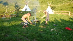 Un terrain de camping avec deux tentes, une table et un foyer.