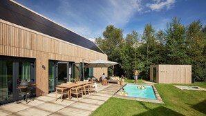 A modern house with a swimming pool, patio furniture, and a wooden deck. - Apartment in Drenthe Near National Park (Appelscha)